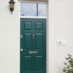 green wooden front door with gold accents
