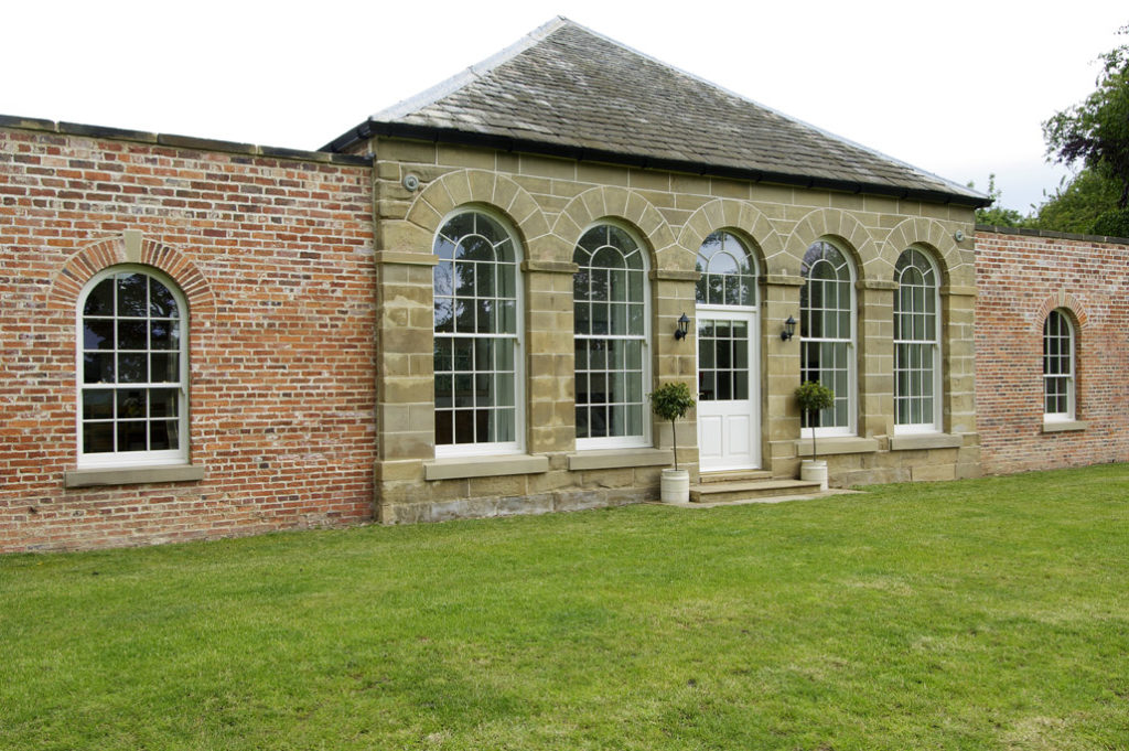 large arched white wooden windows with white wood door