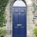 blue wooden door with gold handle and letterbox