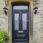 black wooden front door with gold accents