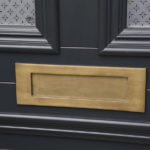 black wooden front door with brushed brass letterbox