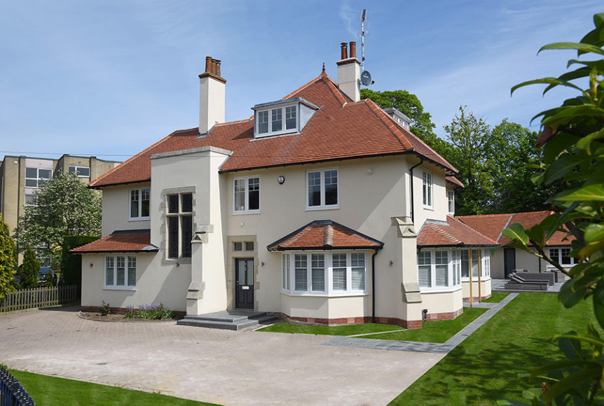 Large white house with white wood windows and black door