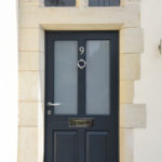 navy blue wooden front door with silver accents
